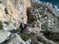 Llegando a la reunión: Solete llegando a la reunión del último largo. A sus espaldas se aprecia cláramente el espolón por donde discurren la vía Costa Blanca, y un escalador, con casco amarillo, más arriba en una de sus reuniones. Escalada en Peñón de Ifach - Llegando a la reunión: Solete llegando a la reunión del último largo. A sus espaldas se aprecia cláramente el espolón por donde discurren la vía Costa Blanca, y un escalador, con casco amarillo, más arriba en una de sus reuniones.