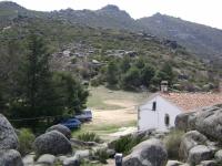 Escalada en Pe�a de la Cruz - Pe�a de la Cruz: El refugio, a la izquierda el sector La Fuente, siempre a la sombra, m�s arriba el Canchal Calavero, con unos 40 bloques (de momento), y m�s arriba el Canchal de la Paloma, con 8 v�as (tambien de momento) cortas pero intensas, entre el IV y el 7b.