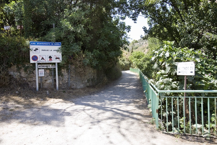 Entrada zona de La Jarra - Saliendo del pueblo por el estadio de fútbol. Continuaremos hasta el siguiente cruce y tomaremos la carretera de San Juan hacia nuestra derecha, en un giro de 360º. En la siguiente curva sale un camino de tierra a la derecha, donde hay una señal que indica Zona de la Jarra (COMO VEMOS EN LA FOTOGRAFÍA). Continuaremos este camino de tierra buscando una senda que sale a nuestra izquierda justo antes de una antigua masía abandonada al final del camino. Continuaremos la senda buscando el cauce del río hacia nuestra derecha. Una vez en el río, remontaremos el barranco hasta llegar al charco de los Peñones, donde nos encontraremos el primer sector.